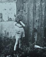 Claudia in Shorts and a T-Shirt Near a Wall